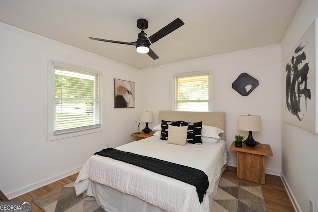 bedroom with ceiling fan, dark hardwood / wood-style flooring, and ornamental molding