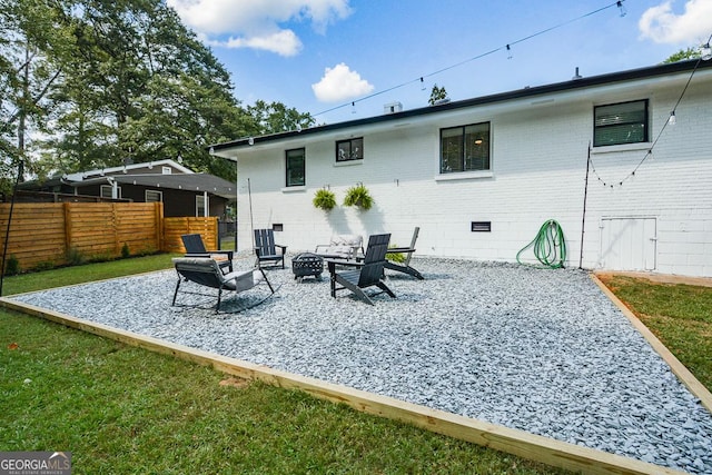 back of house with a yard, an outdoor fire pit, and a patio