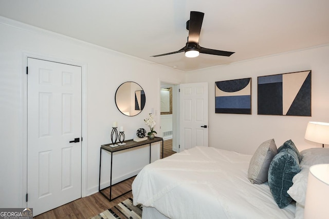 bedroom featuring hardwood / wood-style floors, ceiling fan, and ornamental molding