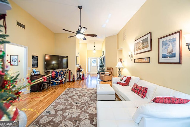 living room with hardwood / wood-style floors, ceiling fan, and lofted ceiling