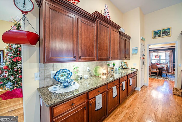 kitchen featuring light stone countertops, light hardwood / wood-style flooring, and tasteful backsplash