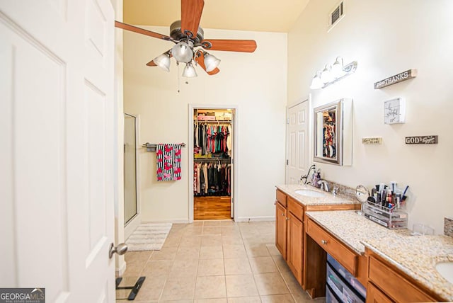 bathroom with tile patterned flooring, vanity, ceiling fan, and a shower with door