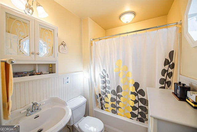 full bathroom featuring sink, shower / bath combination with curtain, and toilet