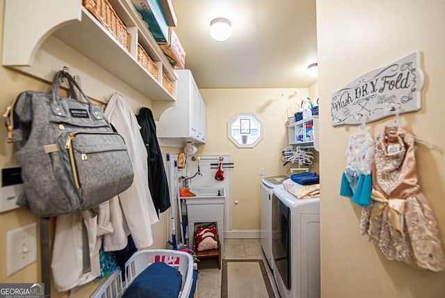 laundry room with cabinets, light tile patterned floors, and separate washer and dryer