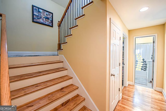 stairs with hardwood / wood-style flooring