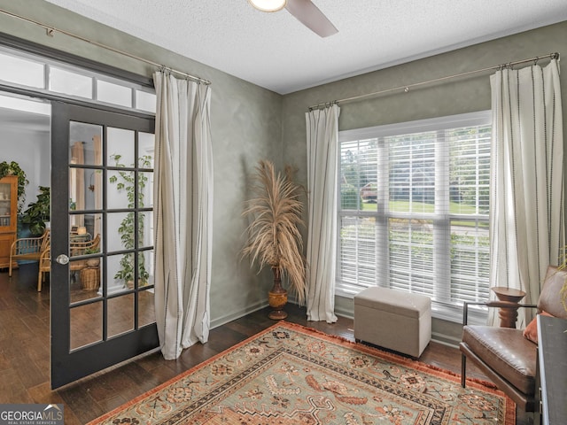 sitting room featuring ceiling fan, dark hardwood / wood-style flooring, and plenty of natural light