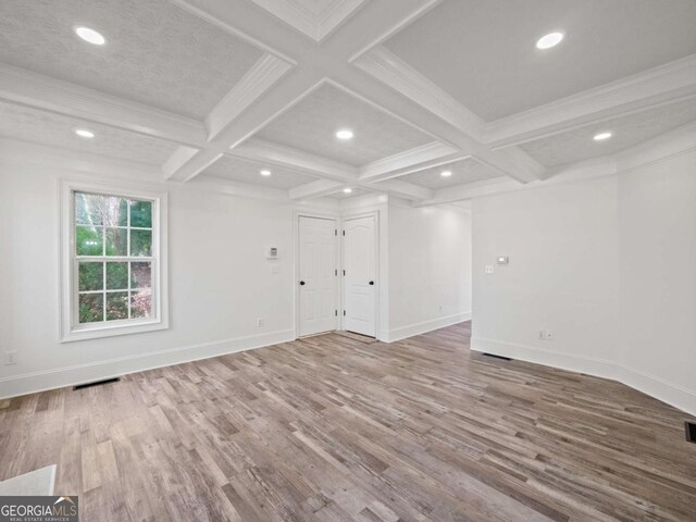 interior space featuring beam ceiling, crown molding, hardwood / wood-style floors, and coffered ceiling