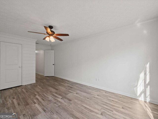 unfurnished bedroom featuring ceiling fan, light hardwood / wood-style floors, a textured ceiling, and ornamental molding