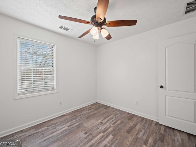 empty room with ceiling fan, wood-type flooring, and a textured ceiling