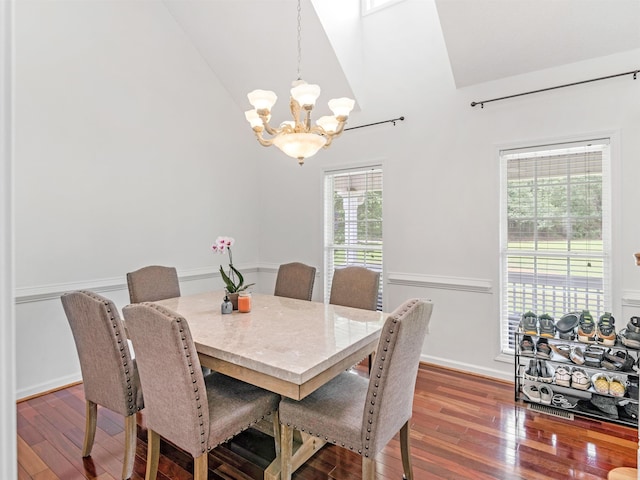 dining room featuring dark hardwood / wood-style flooring, vaulted ceiling, and an inviting chandelier