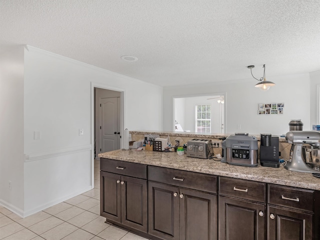 kitchen featuring ceiling fan, dark brown cabinets, light tile patterned floors, and a textured ceiling