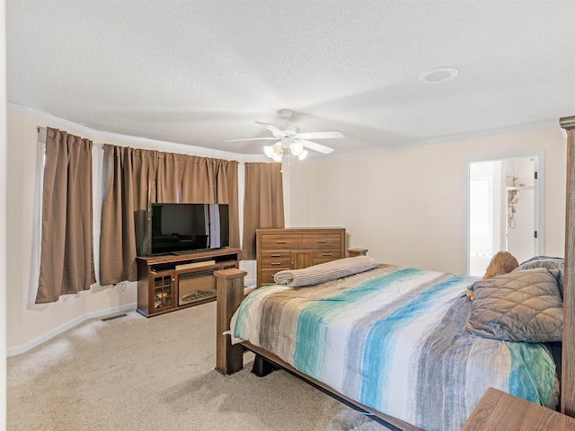 bedroom featuring connected bathroom, ceiling fan, light colored carpet, a textured ceiling, and ornamental molding