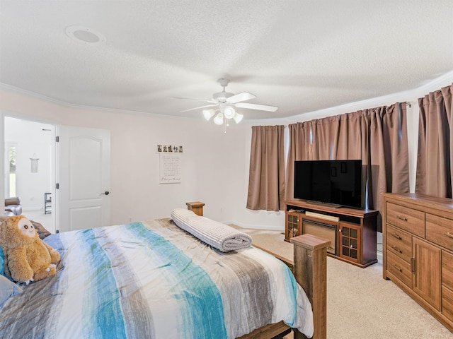 carpeted bedroom with ceiling fan, ornamental molding, and a textured ceiling