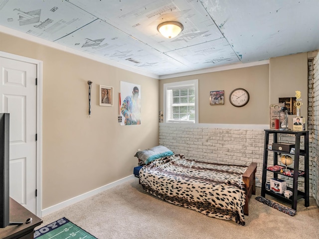 carpeted bedroom with ornamental molding and brick wall