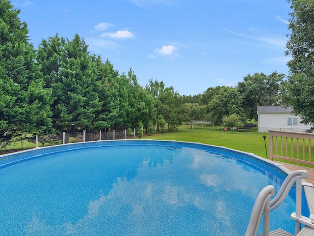 view of pool featuring a lawn