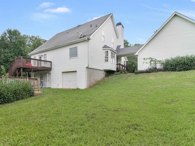 rear view of house with a yard, a deck, and a garage