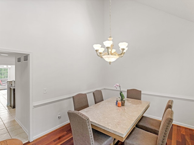 dining area featuring hardwood / wood-style floors and a chandelier