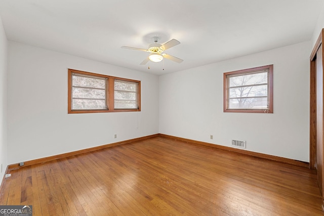 empty room with ceiling fan and light hardwood / wood-style floors