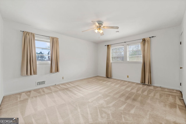 spare room featuring light carpet and ceiling fan