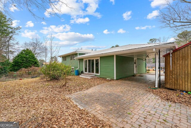 back of house featuring a carport