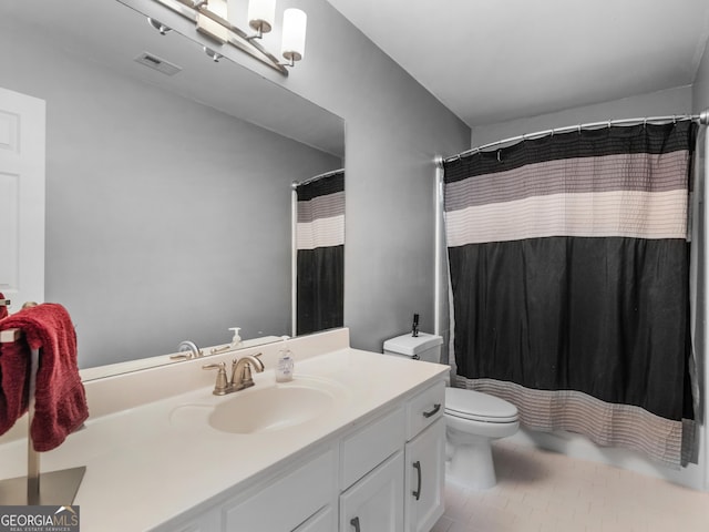 bathroom featuring curtained shower, tile patterned flooring, vanity, and toilet