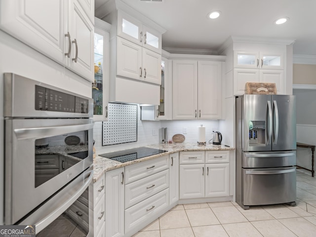 kitchen with light stone countertops, appliances with stainless steel finishes, crown molding, light tile patterned floors, and white cabinetry