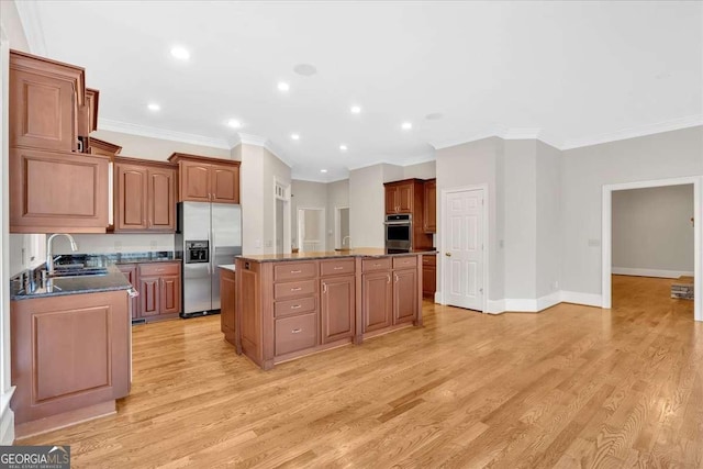 kitchen with dark stone countertops, crown molding, a center island, and appliances with stainless steel finishes