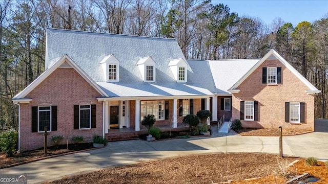 cape cod-style house featuring covered porch