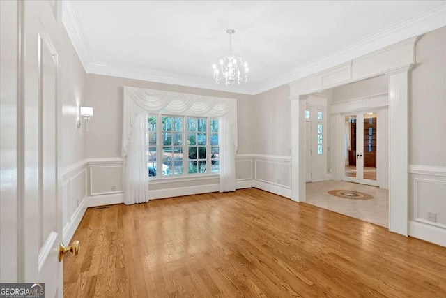 interior space featuring crown molding, light wood-type flooring, and an inviting chandelier