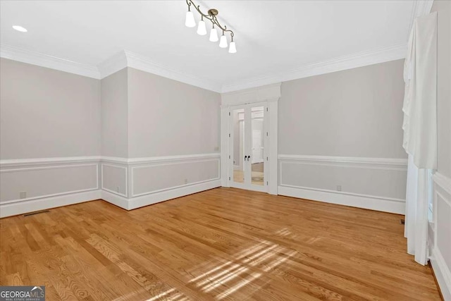 spare room featuring crown molding and wood-type flooring