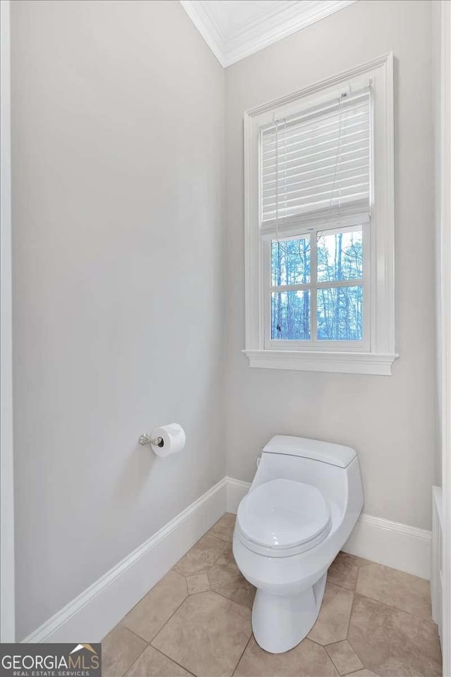 bathroom with tile patterned flooring, toilet, and ornamental molding