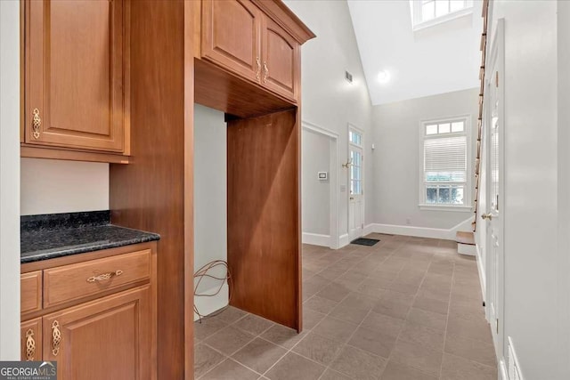 kitchen with dark stone counters and lofted ceiling