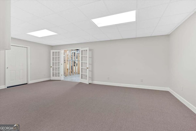 unfurnished room with a drop ceiling, carpet, and french doors