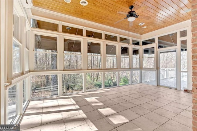 unfurnished sunroom featuring ceiling fan, plenty of natural light, and wood ceiling