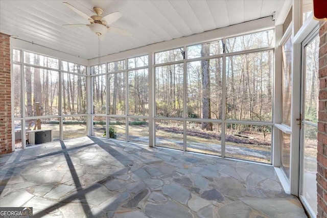 unfurnished sunroom with ceiling fan and a wealth of natural light