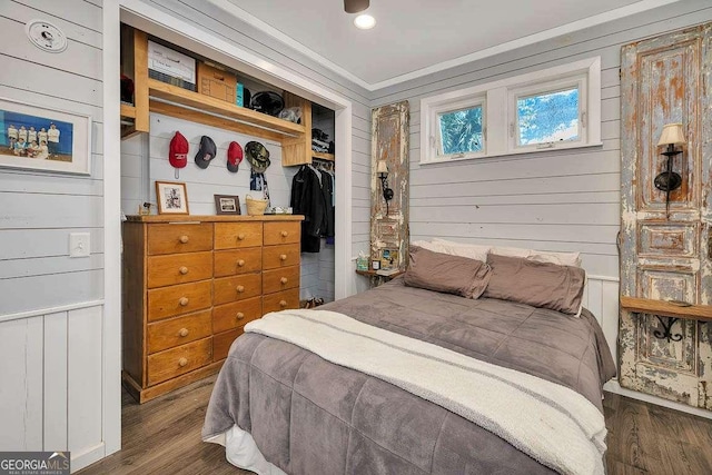 bedroom with crown molding, a closet, and dark wood-type flooring