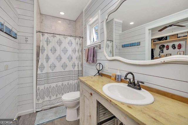 bathroom with hardwood / wood-style flooring, wood walls, sink, and walk in shower