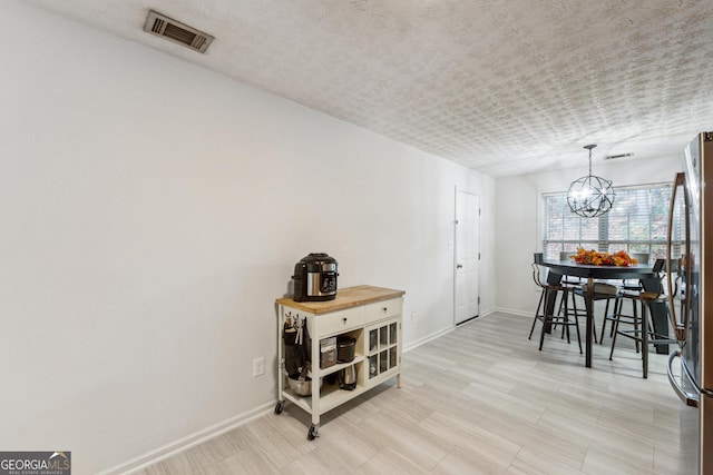 dining space with a textured ceiling and an inviting chandelier