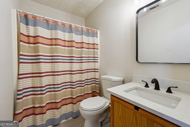 bathroom with hardwood / wood-style floors, vanity, a textured ceiling, and toilet