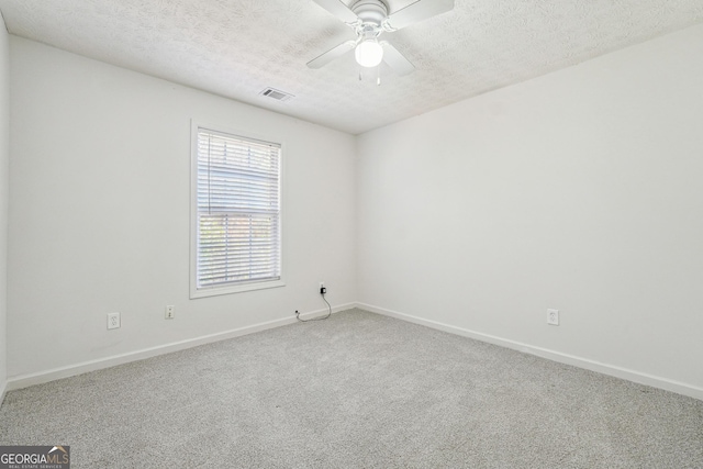 empty room with ceiling fan, carpet floors, and a textured ceiling