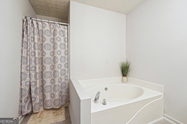 bathroom with a bathtub and a textured ceiling