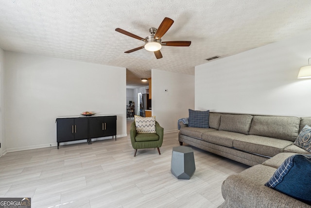 living room with a textured ceiling and ceiling fan