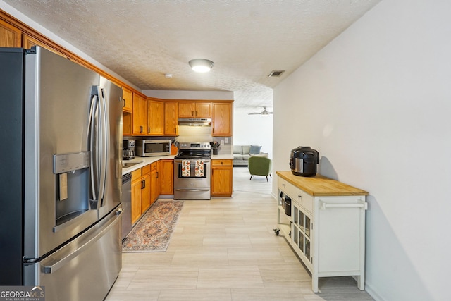 kitchen featuring a textured ceiling and stainless steel appliances