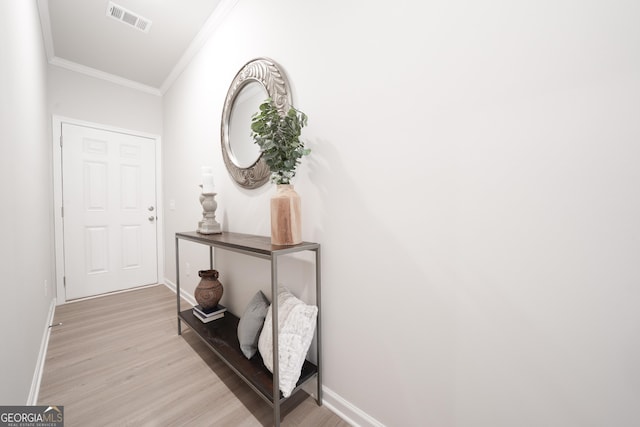 corridor featuring crown molding and light hardwood / wood-style flooring