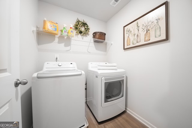 laundry room featuring washer and dryer and dark wood-type flooring