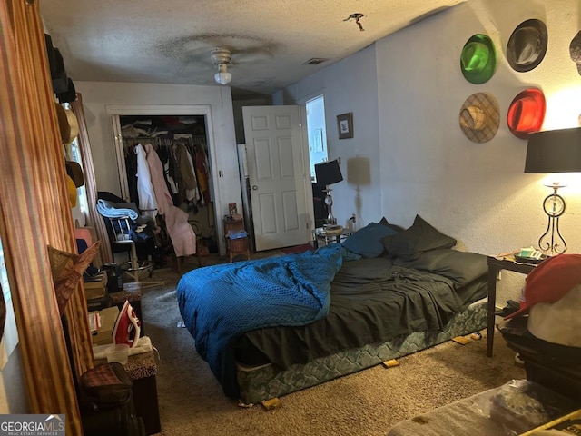 carpeted bedroom featuring ceiling fan, a textured ceiling, and a closet