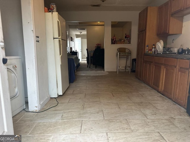 kitchen featuring white fridge and washer / dryer