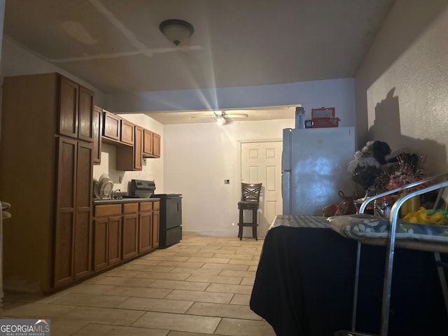 kitchen with white fridge, light hardwood / wood-style flooring, black / electric stove, and ceiling fan