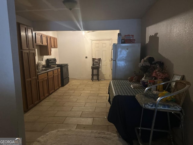 kitchen featuring black range with electric cooktop, sink, and white refrigerator