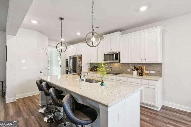 kitchen featuring white cabinets, pendant lighting, sink, and appliances with stainless steel finishes